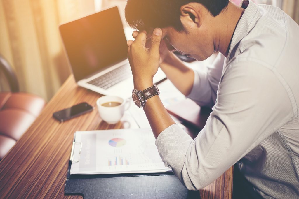 stressed man looking over taxes 